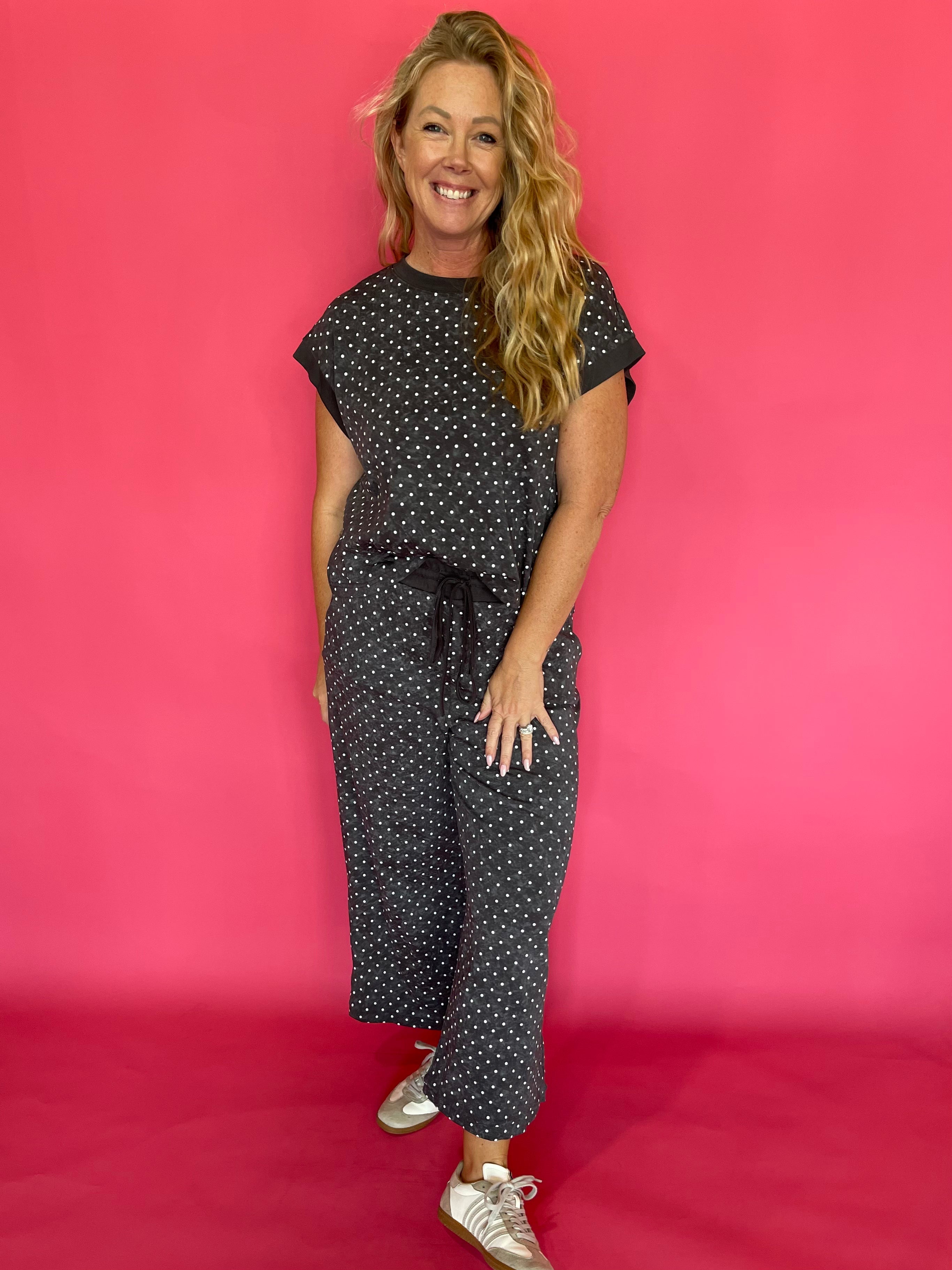Back view of the charcoal polka dot scuba two piece set showing the relaxed cap sleeve top