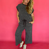 Detail of the elastic drawstring waistband on the charcoal polka dot wide leg cropped pants