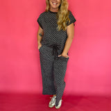Flat lay of the charcoal micro polka dot cap sleeve top and matching wide leg cropped pants