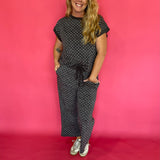 Flat lay of the charcoal micro polka dot cap sleeve top and matching wide leg cropped pants
