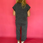 Three quarter view of the charcoal polka dot scuba set styled as an easy travel day outfit