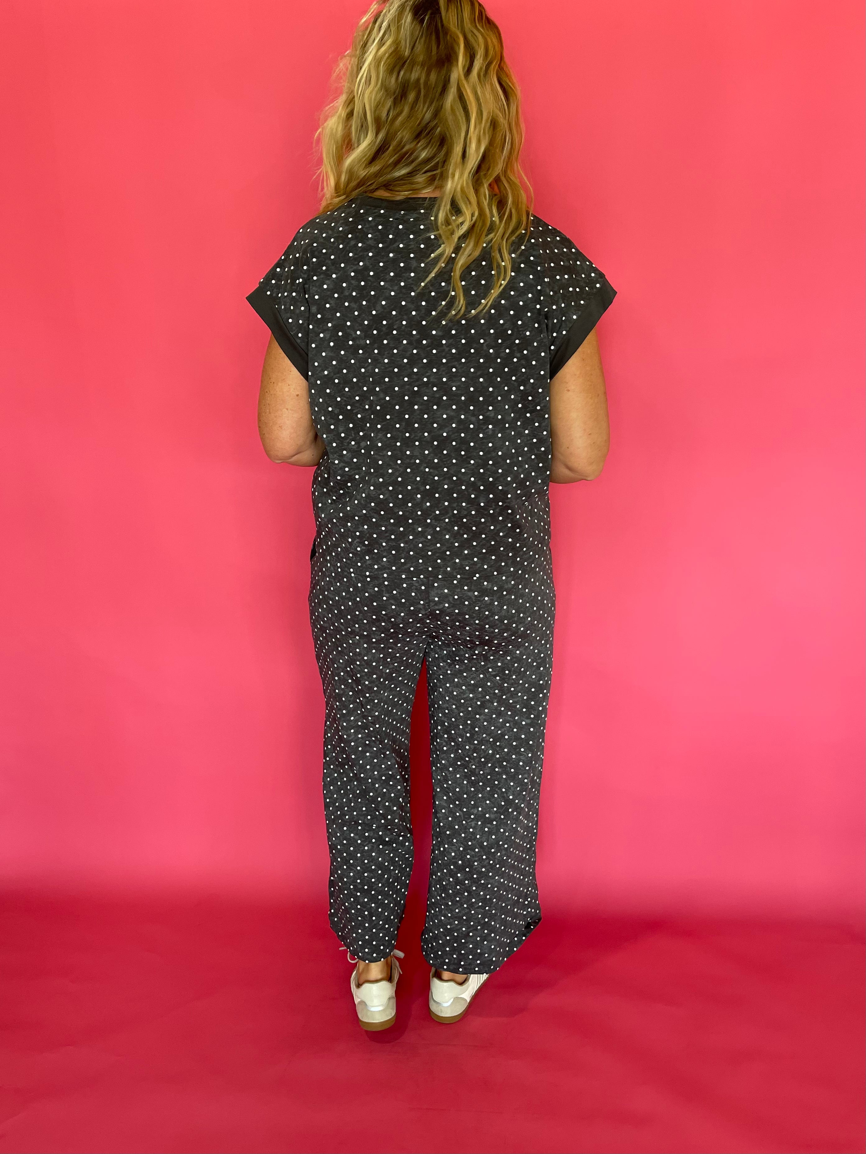 Three quarter view of the charcoal polka dot scuba set styled as an easy travel day outfit