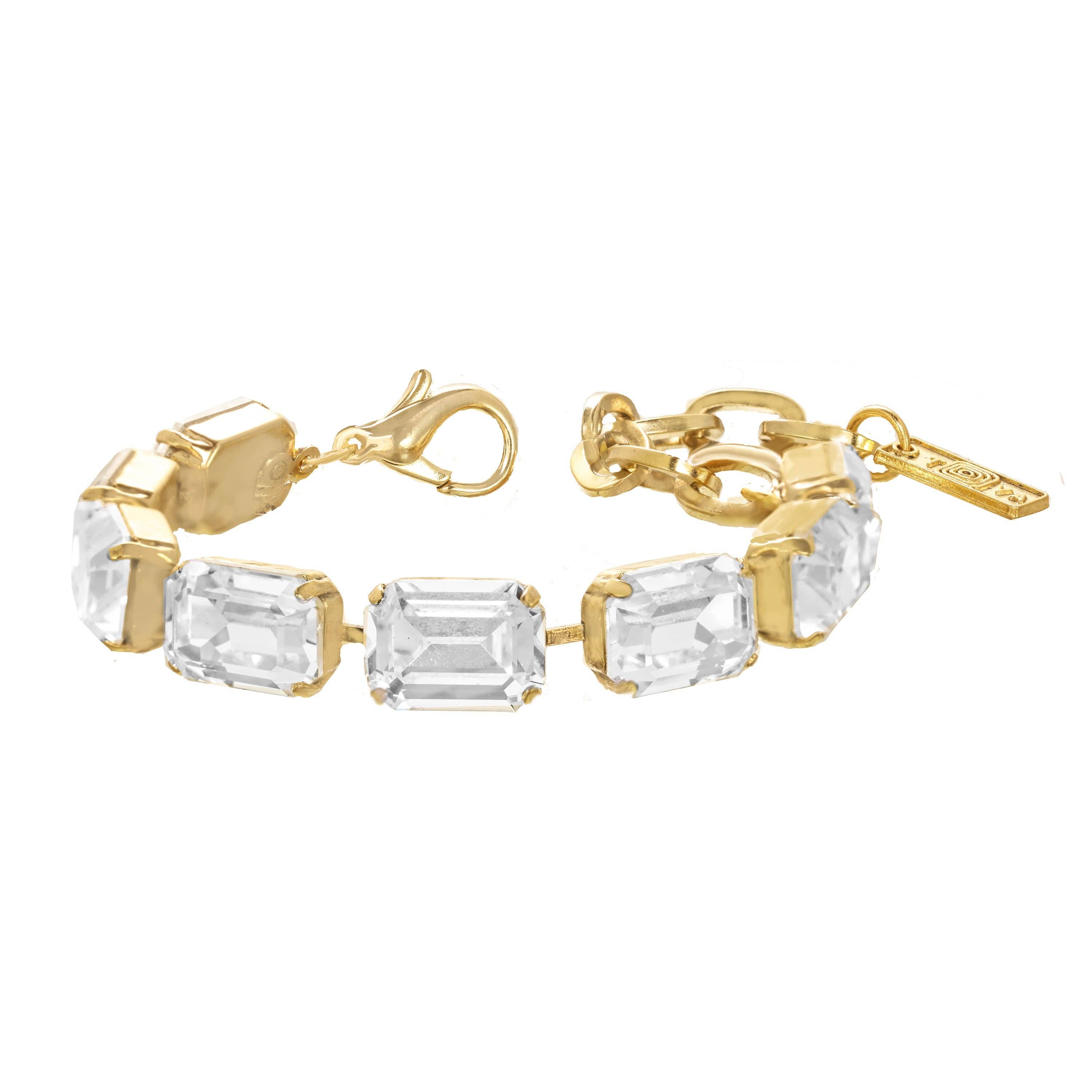 Slim antique gold bracelet set with a line of clear crystals, fastened around a model's wrist