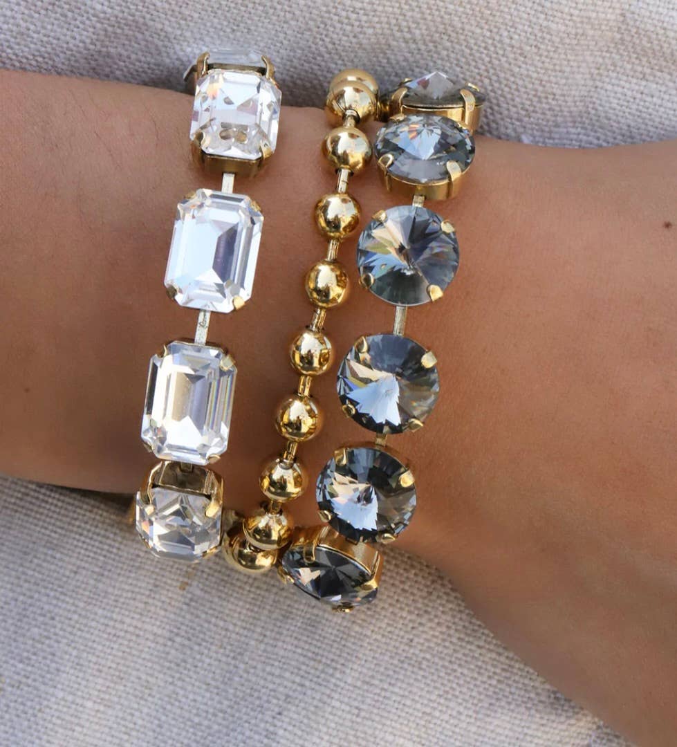 Flat lay of the clear crystal Monique bracelet laid open flat on a neutral background