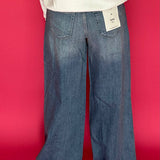 Side view showing the 33 inch inseam and full wide trouser leg in medium wash stretch denim