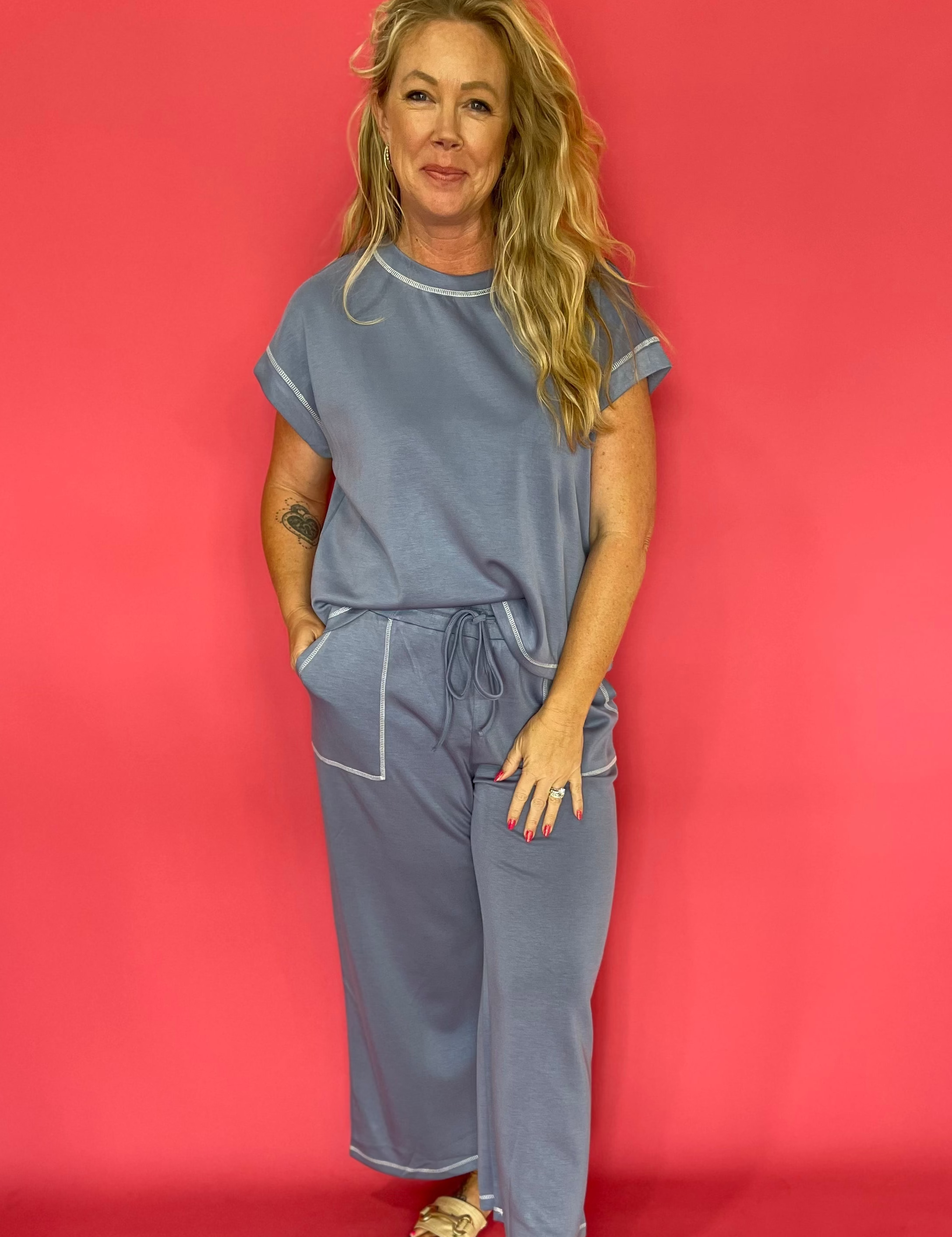 Woman wearing a soft scuba matching set with a cap sleeve crew neck top and wide leg pants