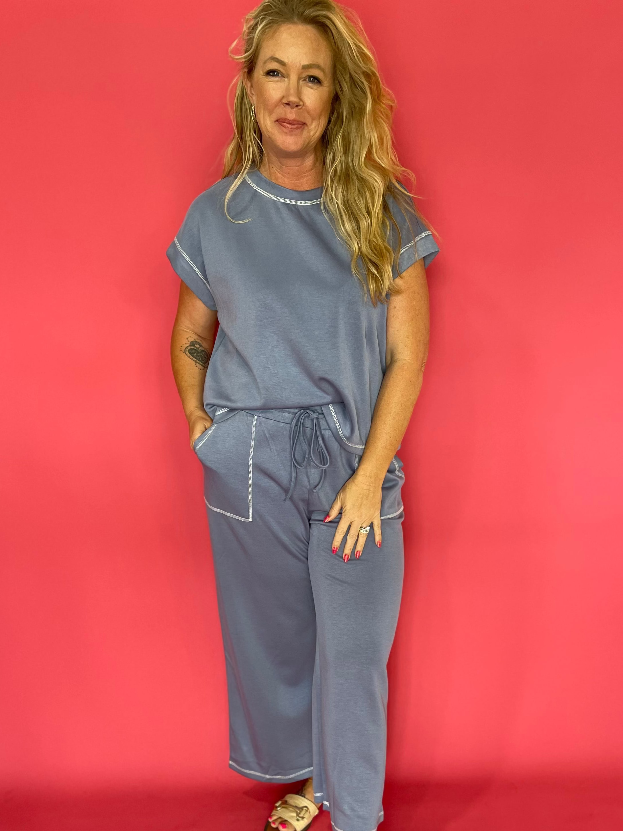 Woman wearing a soft scuba matching set with a cap sleeve crew neck top and wide leg pants