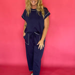 Woman wearing a navy scuba lounge set with a cap sleeve top and wide leg drawstring pants
