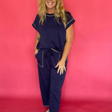 Woman wearing a navy scuba lounge set with a cap sleeve top and wide leg drawstring pants