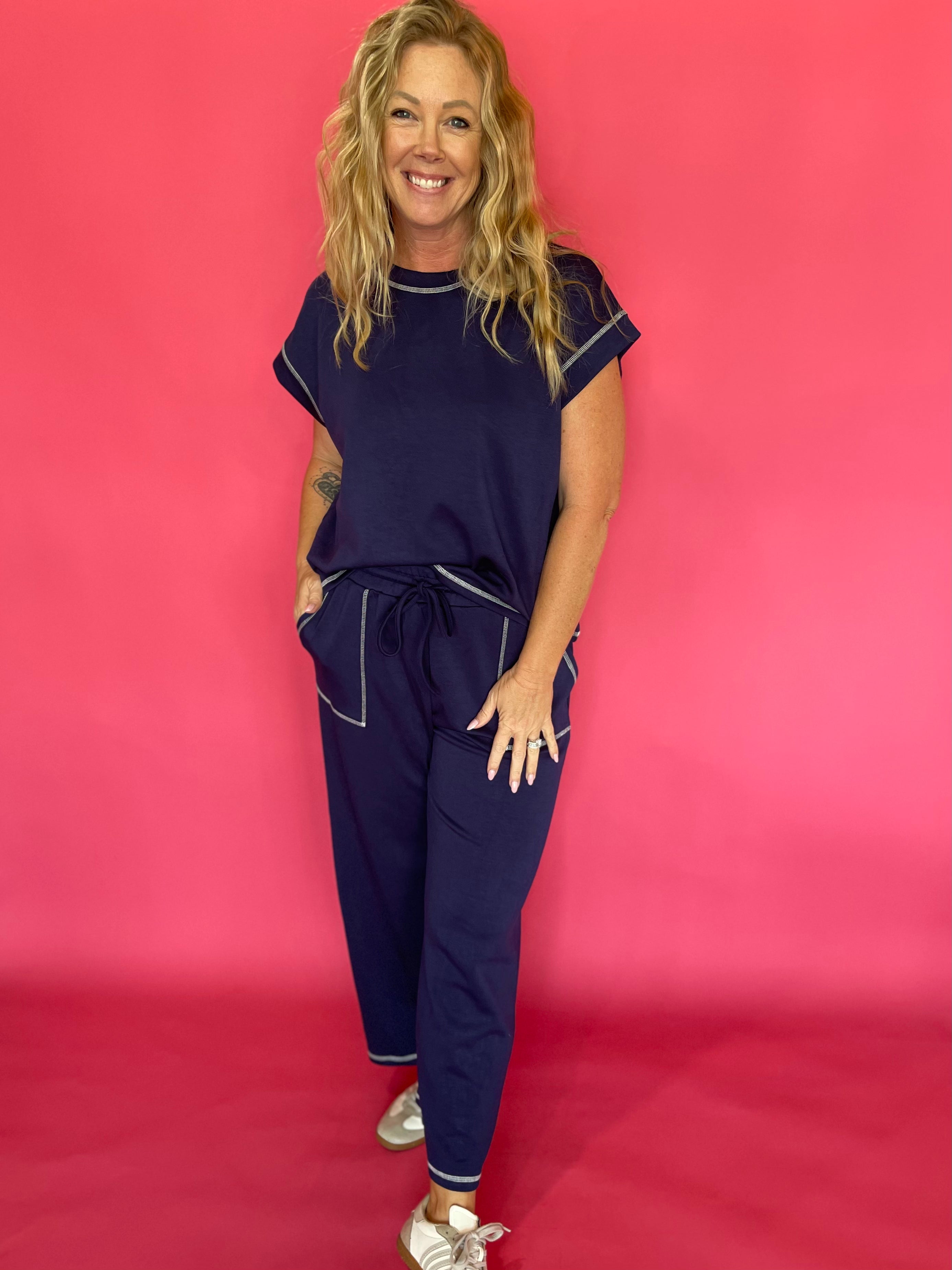 Woman wearing a navy scuba lounge set with a cap sleeve top and wide leg drawstring pants