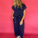 Close-up of the contrast stitching and crew neckline on the navy scuba cap sleeve top