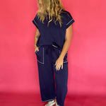Close-up of the contrast stitching and crew neckline on the navy scuba cap sleeve top