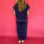 Flat lay of the navy scuba lounge top and pants laid out together as a matching set