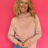 Woman wearing an oversized yarn-dyed striped mock neck long sleeve tee over straight leg denim and sneakers