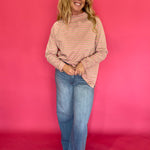 Side view showing the relaxed oversized drape and long raglan sleeves of the striped mock neck tee