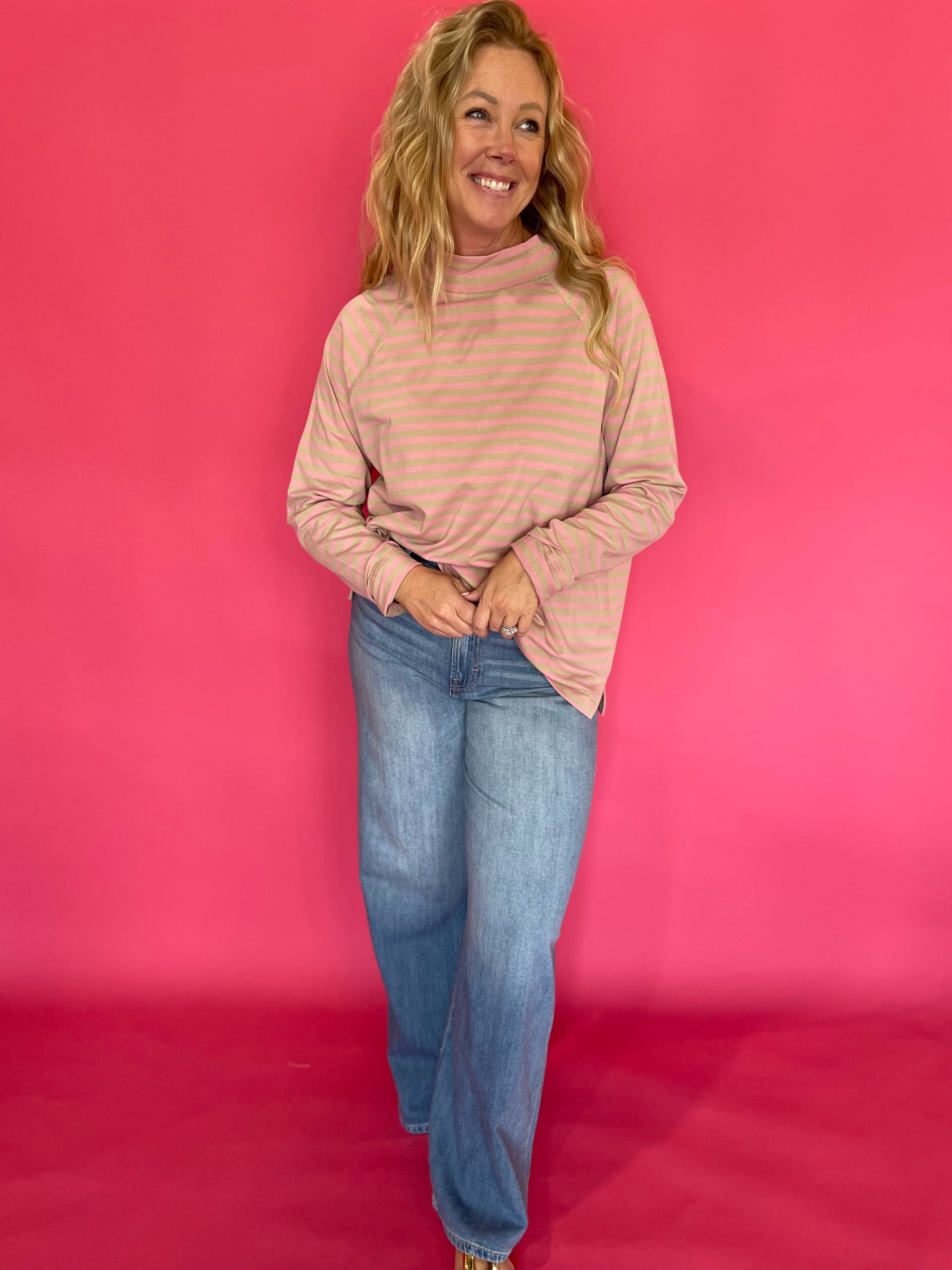 Side view showing the relaxed oversized drape and long raglan sleeves of the striped mock neck tee