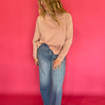 Detail of the ribbed cuff and cropped hem on the striped oversized mock neck long sleeve tee