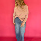 Detail of the ribbed cuff and cropped hem on the striped oversized mock neck long sleeve tee