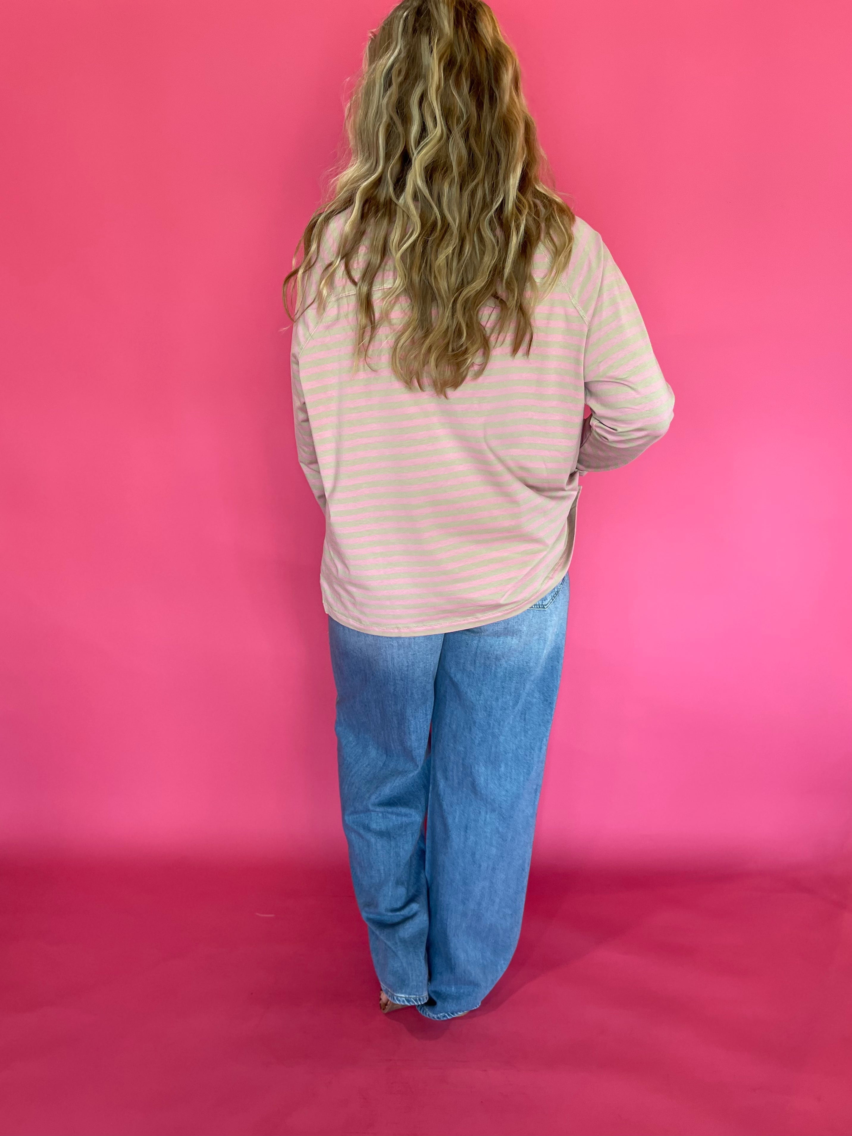 Full length view of the oversized striped mock neck tee worn over straight leg denim