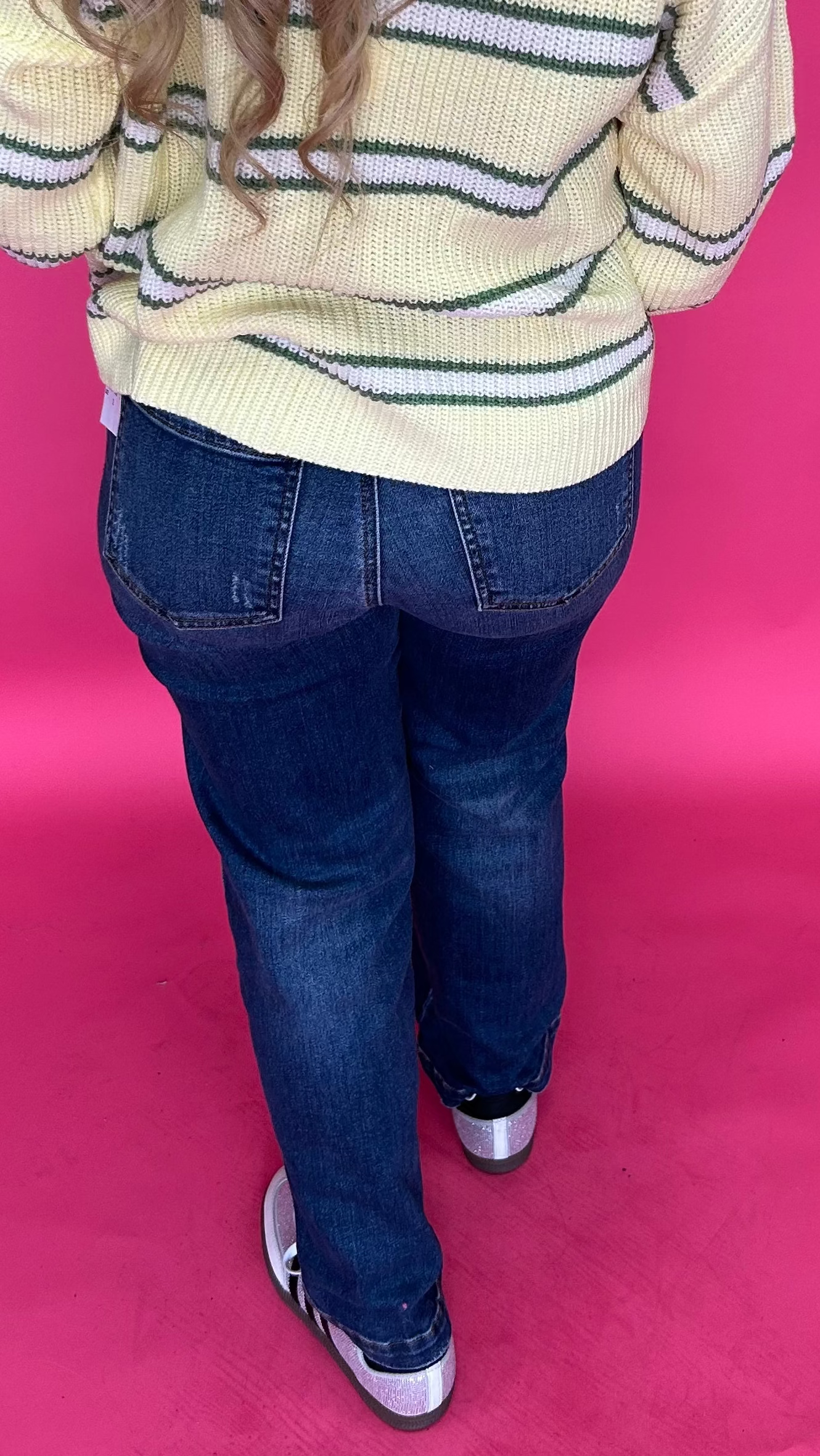 Detail of the high rise waistband and button front closure on the straight leg stretch denim jeans