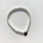 Single strand of small faux pearls on an elastic stretch bracelet that fits most wrists