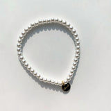 Single strand of small faux pearls on an elastic stretch bracelet that fits most wrists