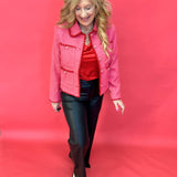 Detail of the textured tweed weave and functional front pocket on the pink jacket