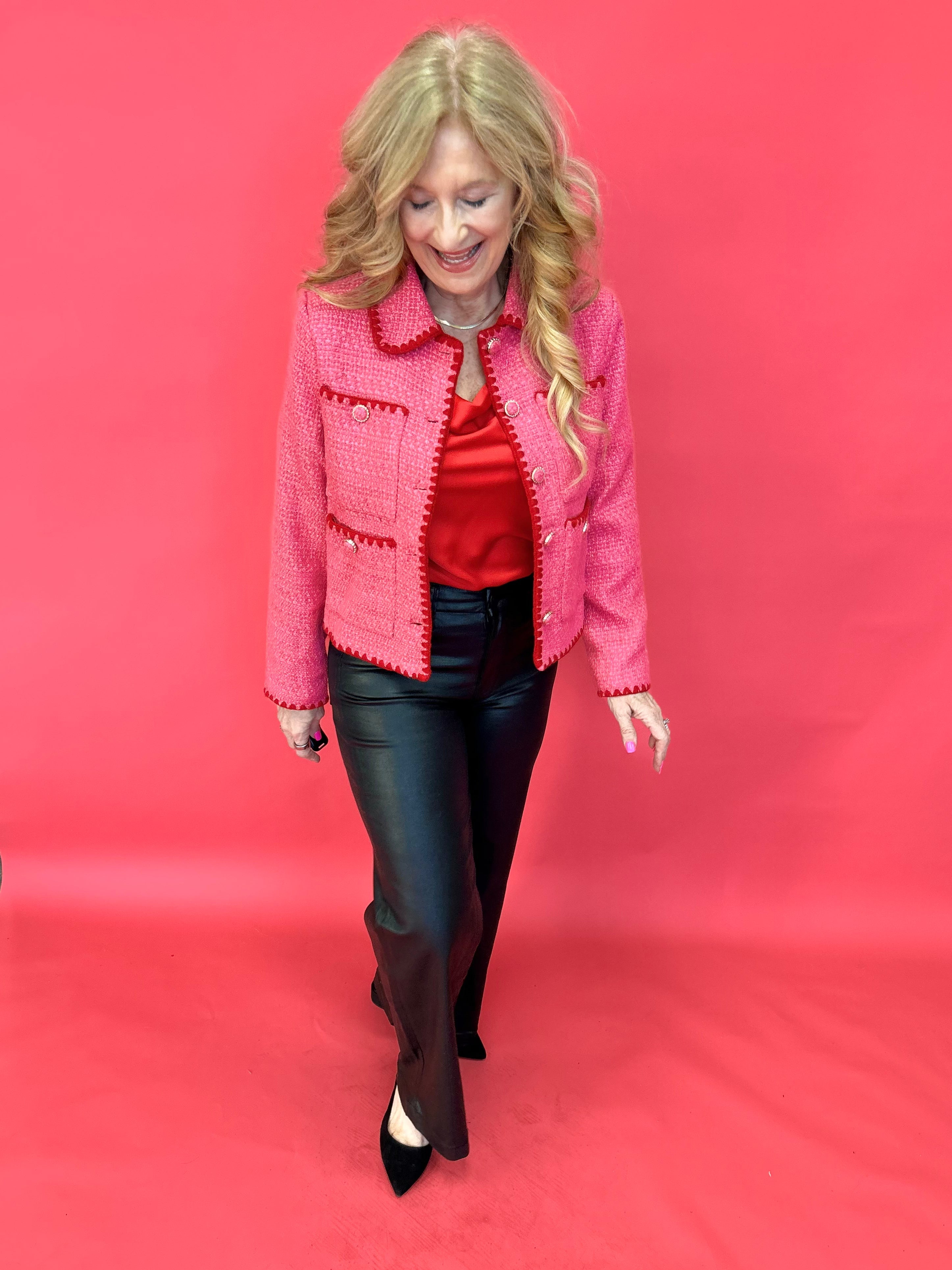 Detail of the textured tweed weave and functional front pocket on the pink jacket