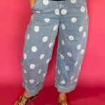 Woman wearing light wash high waist polka dot barrel leg jeans with a fitted knit top