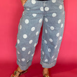 Woman wearing light wash high waist polka dot barrel leg jeans with a fitted knit top