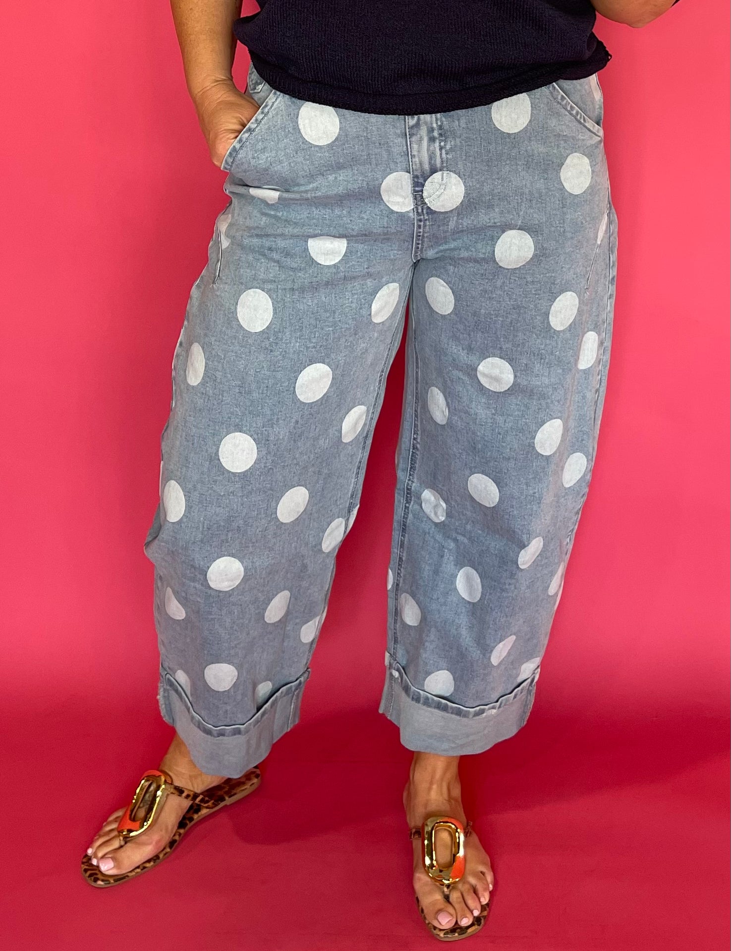 Woman wearing light wash high waist polka dot barrel leg jeans with a fitted knit top