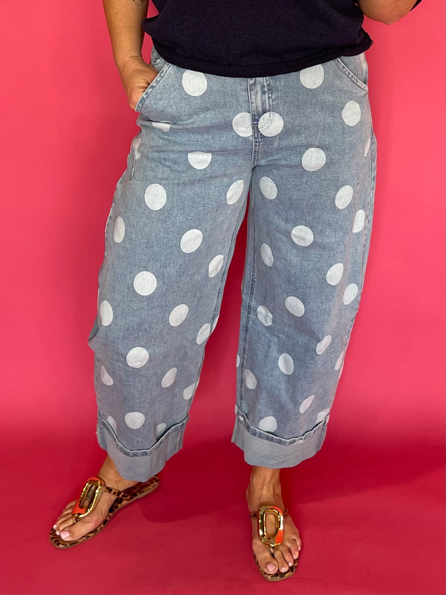 Woman wearing light wash high waist polka dot barrel leg jeans with a fitted knit top