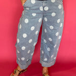 Woman wearing light wash high waist polka dot barrel leg jeans with a fitted knit top