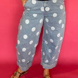 Woman wearing light wash high waist polka dot barrel leg jeans with a fitted knit top
