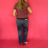 Full length view of the burgundy gingham popcorn texture top tucked into high rise jeans