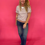 Close-up of the ribbed round neckline and contrast V-stitch detail on the striped top