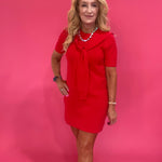 Detail of the short sleeve and shoulder seam on the red tie neck dress