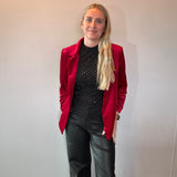 Detail of the decorative sleeve buttons and soft stretch velvet on the red blazer