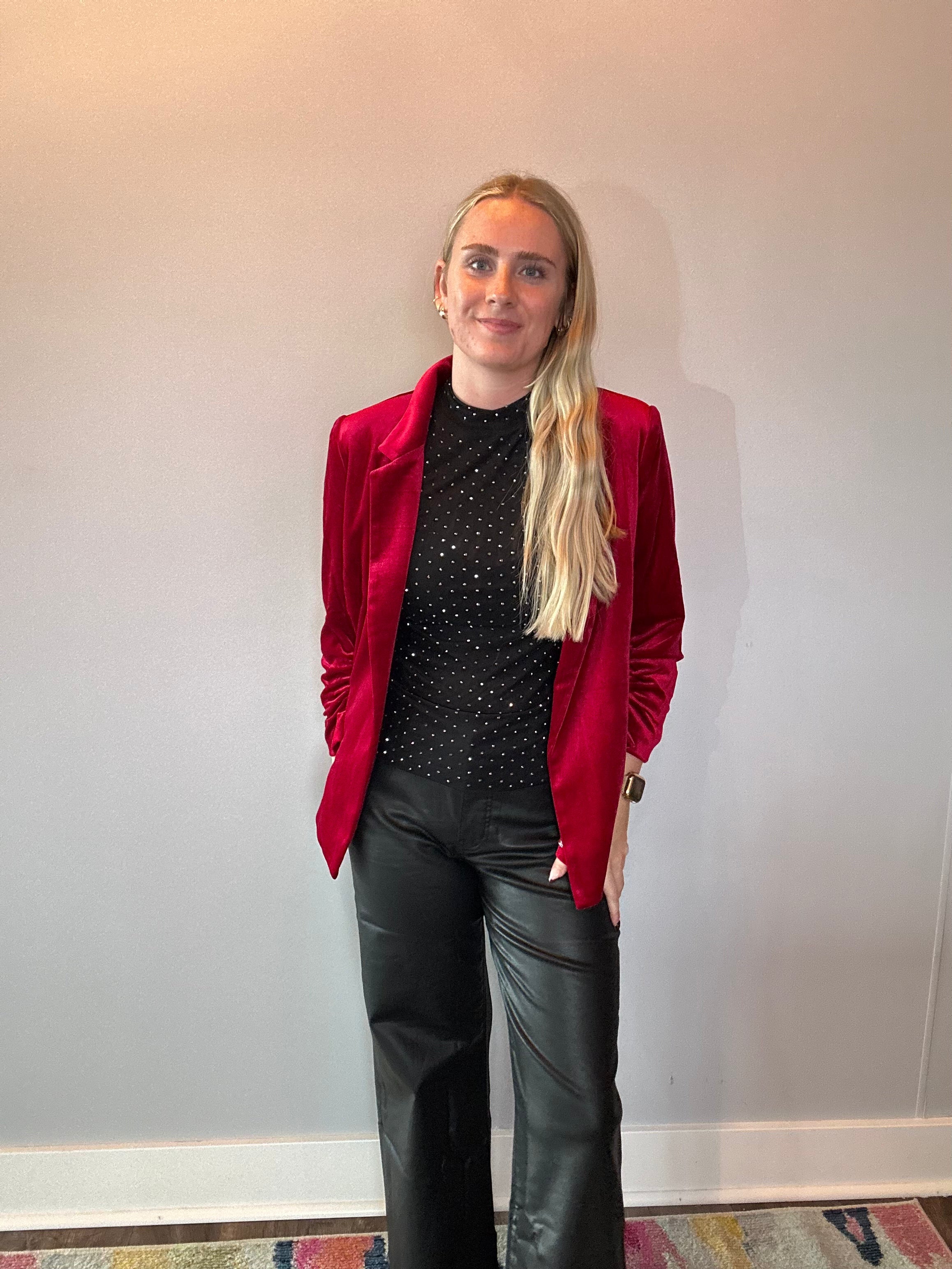 Detail of the decorative sleeve buttons and soft stretch velvet on the red blazer