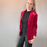 Woman styling the red velvet blazer over a graphic tee with denim for a casual look