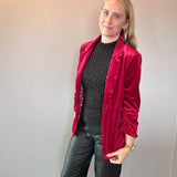 Woman styling the red velvet blazer over a graphic tee with denim for a casual look