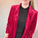 Side view of the tailored red velvet blazer showing the sleeve length and hip-length cut