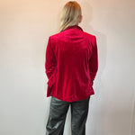 Detail of the rich red velvet texture and soft sheen across the shoulder seam of the blazer