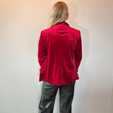 Detail of the rich red velvet texture and soft sheen across the shoulder seam of the blazer