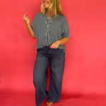 Denim button-up knotted at the waist over white denim with turquoise jewelry and boots