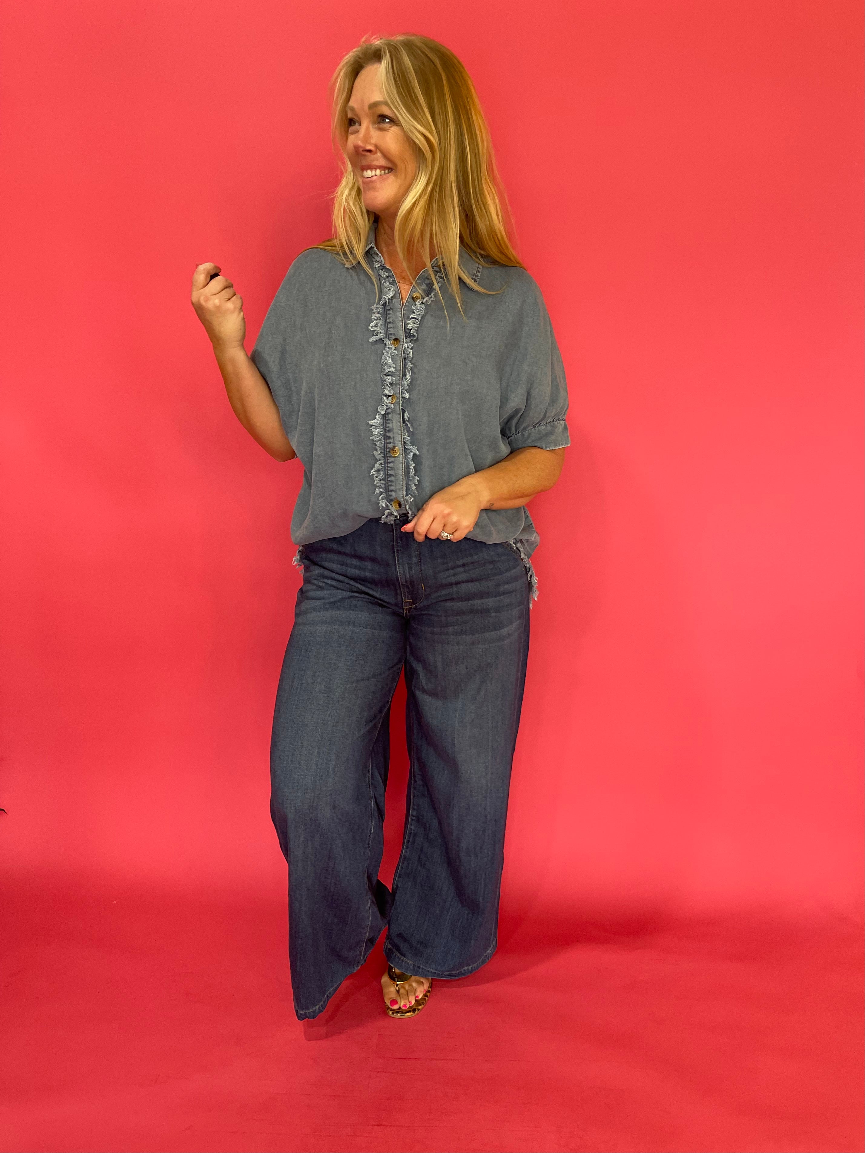 Denim button-up knotted at the waist over white denim with turquoise jewelry and boots