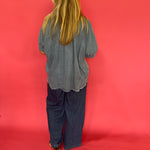 Full length view of the mineral wash denim button up worn knotted over white denim