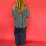 Full length view of the mineral wash denim button up worn knotted over white denim