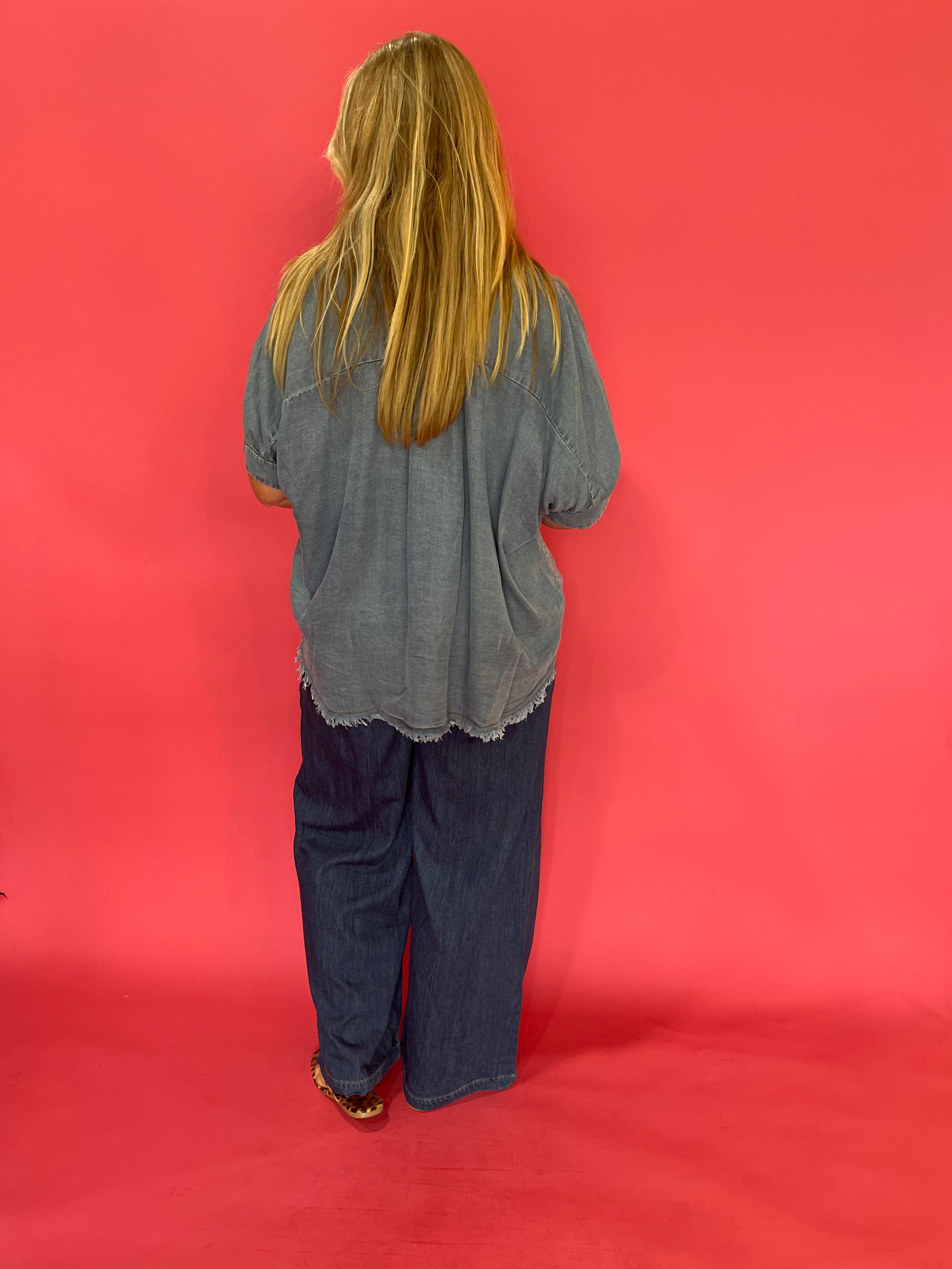 Full length view of the mineral wash denim button up worn knotted over white denim