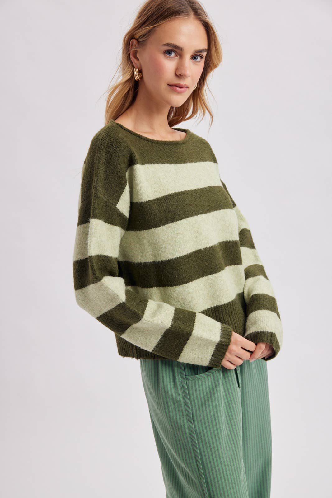 Close-up of the sleeve and shoulder on the brown and sky striped cozy knit boatneck sweater